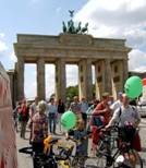 Menschen mit grünen Luftballons vor Brandenburger Tor