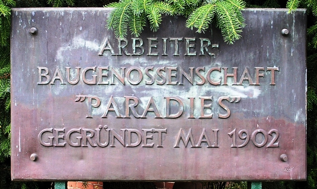 Gedenktafel aus Metall mit der Aufschrift: Arbeiter-Baugenossenschaft Paradies, gegründet Mai 1902.
